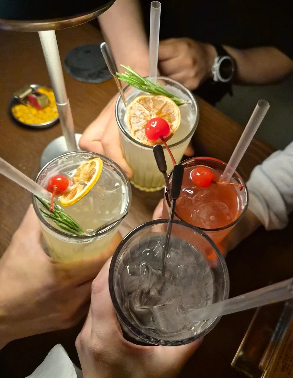 칵테일 잔 네 개를 맞대어 건배하는 손